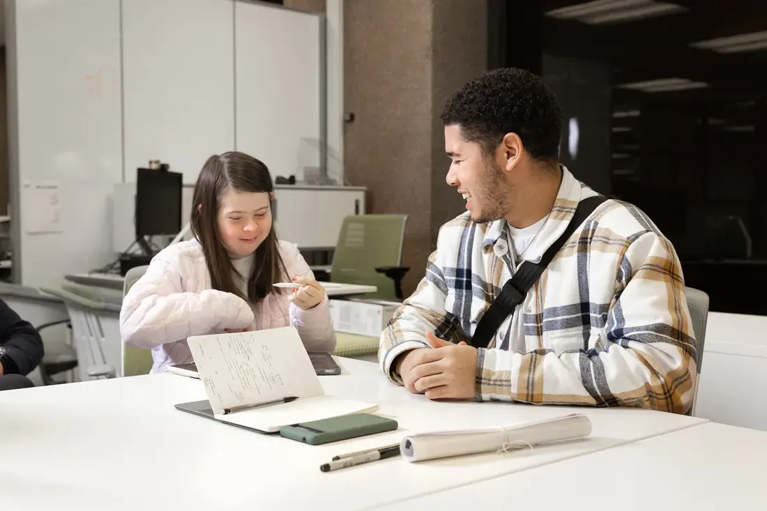 Two students sitting in chairs.